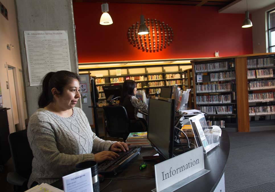 Library staff at the service desk area at the International District/Chinatown Branch