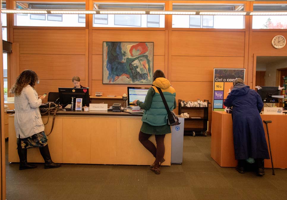 Library patrons at the service desk area at the Montlake Branch