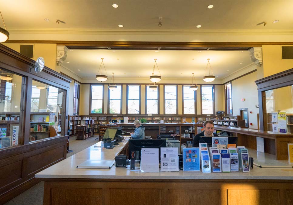 Library staff at service desk area at the West Seattle Branch